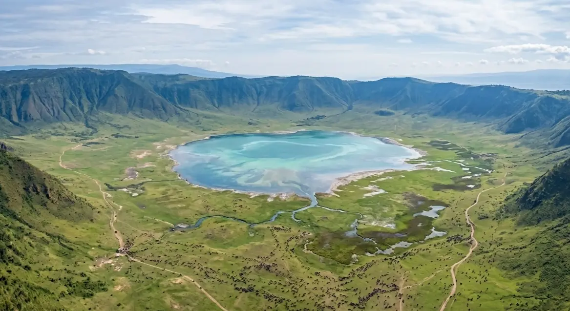 Aerial view of the Ngorongoro Crater green landscape, central lake, and surrounding caldera walls.